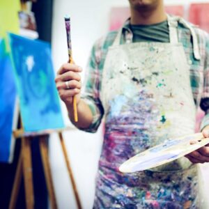 Man holding brush in art studio